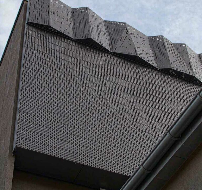 Perforated aluminum facade panels on modern commercial building exterior